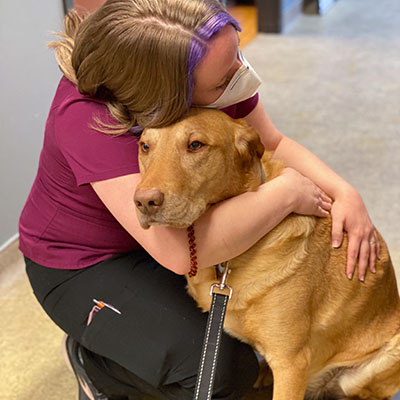 slider-1 A staff member hugging. a dog at Pikes Peak Veterinary Clinic, Colorado Springs.